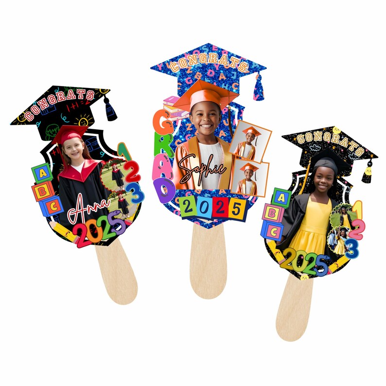 May include: Three graduation-themed photo props on wooden sticks. Each prop features a photo of a child in graduation attire, the word "CONGRATS", and the year "2025". The props have colorful designs with letters, numbers, and graduation caps.