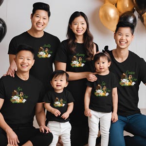 May include: A family of five wearing black t-shirts with a jungle animal theme. The shirts have the words "Bro", "Sis", "Mommy", "Daddy", and "Cousin" with the number "One" on each shirt.