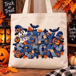 May include: A cream-colored canvas tote bag featuring a graphic print with the text STAY SPOOKY. The design includes a white ghost, orange pumpkins, blue witch hats, bats, and autumn leaves, accented with blue plaid patterns and small buttons.