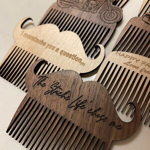 May include: A set of four wooden combs with mustache-shaped handles. The combs are engraved with different sayings, including "I moustache you a question", "The stash life chose me", and "Happy Father's Day".