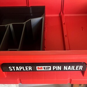 May include: Red plastic tool box with a black insert and a label that reads "Stapler M12 Pin Nailer".