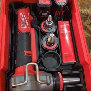 May include: A red and black Milwaukee FUEL tool kit. The kit includes a red and black power tool, batteries, and various attachments. The kit is stored in a red, hard-shell case with a clear lid.