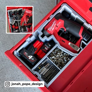 May include: A red Milwaukee FUEL drill and driver is stored in a red toolbox with a gray foam insert. The toolbox also contains two Milwaukee 4.0 Ah batteries, a variety of screws, and a set of drill bits.