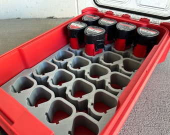 May include: Red and gray plastic storage case with a clear lid, designed to hold multiple batteries. The case has a foam insert with multiple slots for batteries.