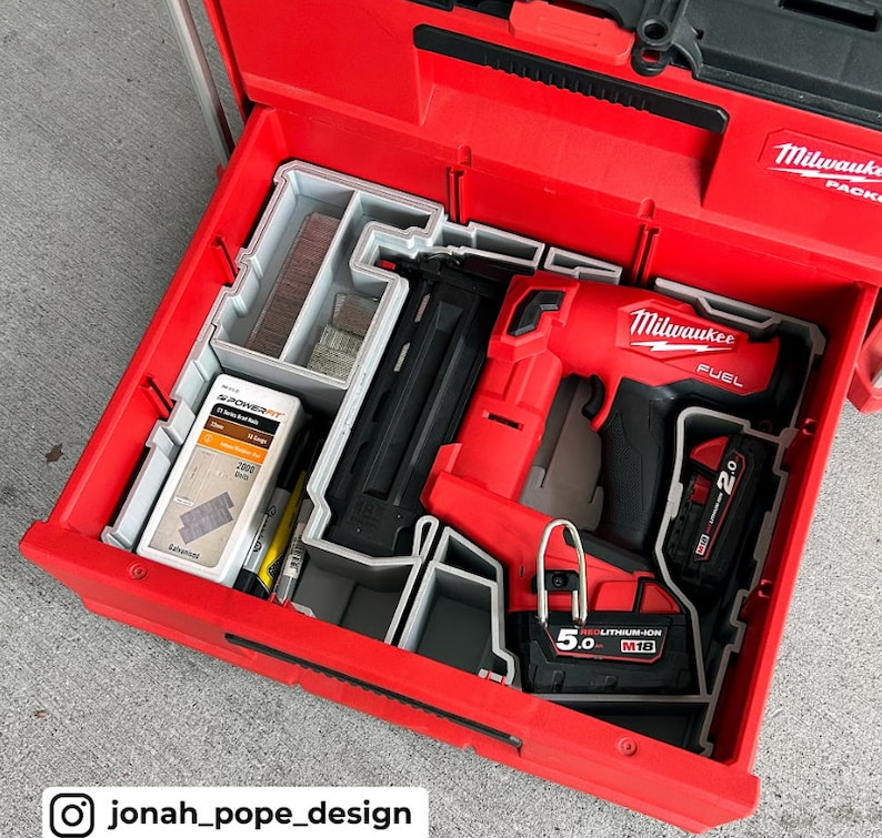 May include: A red Milwaukee FUEL 2.0 cordless brad nailer with a gray and black plastic storage case. The nailer is in a red toolbox with a gray foam insert. The nailer has a 5.0 Ah REDLITHIUM-ION M18 battery.