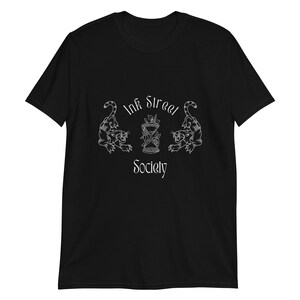 Puede incluir: Camiseta negra con un diseño gráfico blanco que presenta dos panteras estilizadas que flanquean un reloj de arena con el texto "Ink Street Society" en una fuente cursiva.