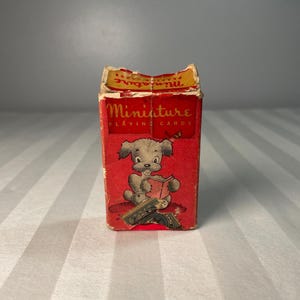Mazzo di carte da gioco vintage in miniatura da 52 carte in scatola con disegno di cane che legge un libro e timbro fiscale, anni '50