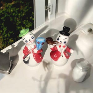 Conjunto de dois saleiros e pimenteiros de boneco de neve e mulher da neve da Artmark, casaco vermelho, chapéu verde, cartola e cachimbo enorme!