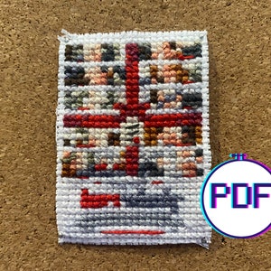 May include: A colorful cross-stitch pattern with red, white, and blue accents. The pattern is framed in white and has a white background.