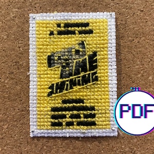 May include: A yellow cross-stitch pattern with a black and gray image of a horse's head. The pattern is framed with a white border.