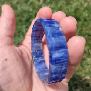 May include: A blue kyanite bracelet made of faceted, rectangular beads. The bracelet is made of natural stone and has a polished finish.