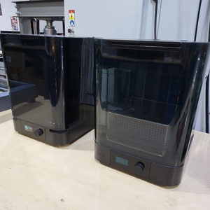May include: Two black, rectangular, countertop appliances with a clear, glass door. The appliance on the left has a control panel with a knob. The appliance on the right has a control panel with a knob and a digital display.