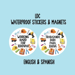 May include: Waterproof stickers and magnets with construction-themed illustrations. The design includes a hard hat, tools, and the text "Working Hard for Jehovah" in English and Spanish. The background is light blue.