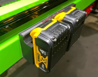 Może przedstawiać: Dwa czarne i żółte akumulatory DeWalt 20V XR litowo-jonowe 4Ah zamontowane na zielonym organizerze narzędzi.