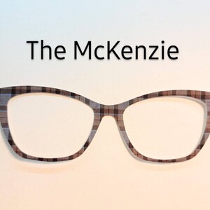 May include: A pair of cat-eye glasses with a brown and white plaid pattern. The glasses are called "The McKenzie".