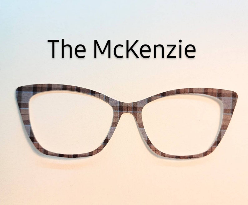 May include: A pair of cat-eye glasses with a brown and white plaid pattern. The glasses are called "The McKenzie".