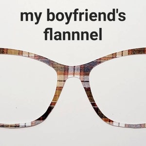 May include: A graphic of eyeglasses with a plaid pattern in shades of brown, tan, and black. The text "my boyfriend's flannel" is above the glasses on a white background.