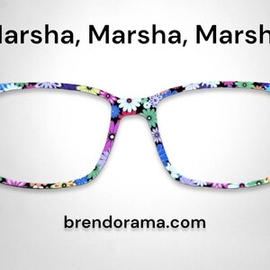 May include: A pair of black square-shaped glasses with a floral print in shades of blue, pink, green, and yellow. The text "Marsha, Marsha, Marsha" is above the glasses and "brendorama.com" is below the glasses.