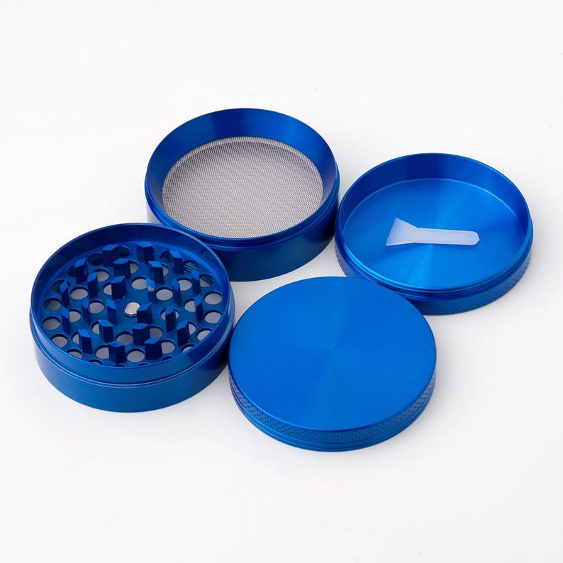 May include: Four piece blue metal grinder with a screen and a scraper. The grinder has a textured surface.