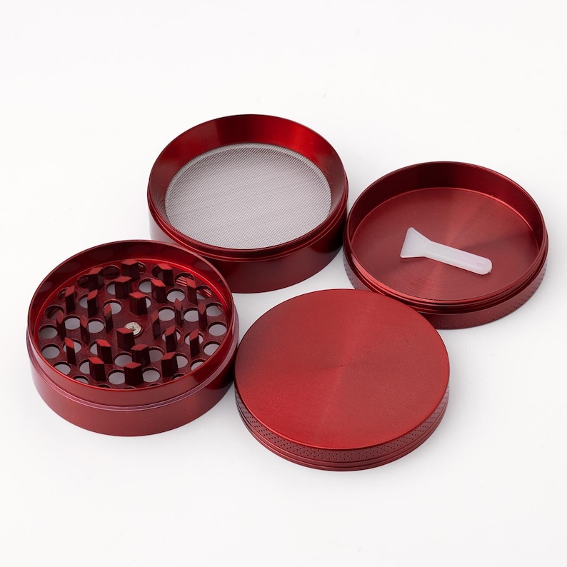 May include: Four piece red metal grinder with a screen and a small plastic scraper.