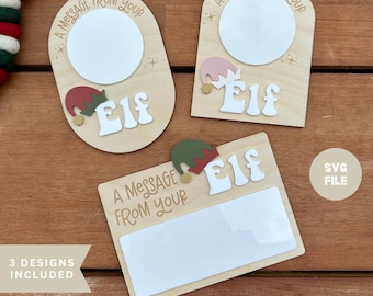 May include: Three wooden Elf message boards with white blank spaces for notes. Each board has the text "A Message From Your" and "Elf". One board is rectangular, and two are arched. A SVG file is included.