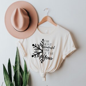 May include: A white t-shirt with a black snowflake design and the text "The Most Wonderful Time Of The Year".