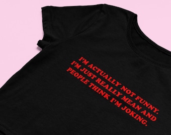 Può includere: Maglietta nera a maniche corte e testo rosso che dice "I'M ACTUALLY NOT FUNNY. I'M JUST REALLY MEAN AND PEOPLE THINK I'M JOKING."