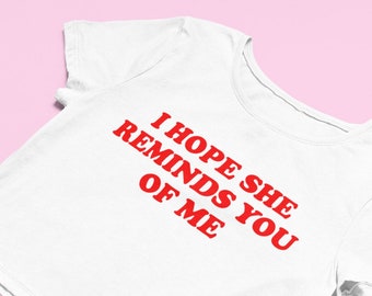 May include: White cropped t-shirt with red text that reads "I hope she reminds you of me."