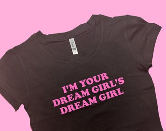 May include: Black cropped t-shirt with pink text that reads "I'm your dream girl's dream girl."