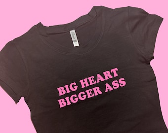 May include: A black cropped t-shirt with short sleeves and the text "BIG HEART BIGGER ASS" printed in pink.