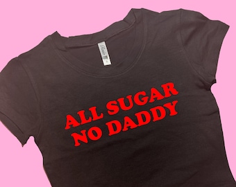 May include: Black cropped t-shirt with red text that reads "All Sugar No Daddy".