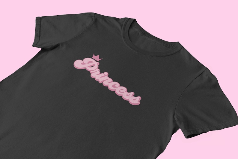 May include: Black t-shirt with a pink retro-style graphic that says "Princess" with a crown above the word.