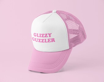 May include: A white and pink trucker hat with a pink mesh back. The front of the hat has the text "GLIZZY GUZZLER" in pink letters.