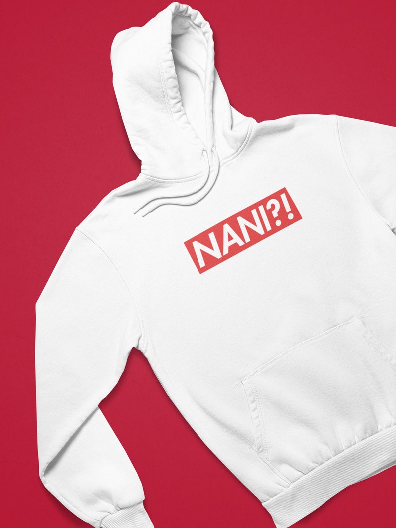 K&ouml;nnte beinhalten: Wei&szlig;er Kapuzenpullover mit Fronttasche und Kordelzug. Der rote rechteckige Aufdruck auf der Brust zeigt "NANI?!" in wei&szlig;en Gro&szlig;buchstaben. Der Hintergrund ist einfarbig rot.