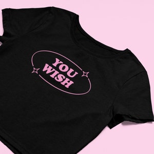 May include: Black cropped t-shirt with a pink oval graphic that says "YOU WISH" with two pink stars on either side of the oval.