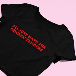 May include: Black cropped t-shirt with red text that reads "I'll just have the chicken tenders".