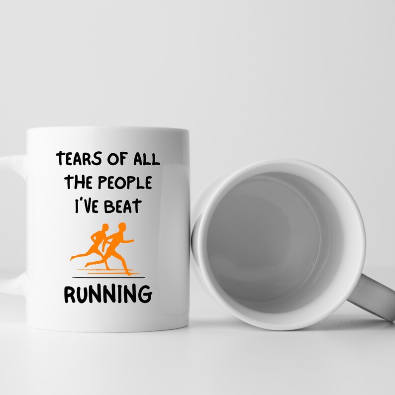 K&ouml;nnte beinhalten: Wei&szlig;e Keramik-Tasse mit dem Text "TEARS OF ALL THE PEOPLE I'VE BEAT RUNNING" in schwarzer Schrift. Eine orangefarbene Grafik von zwei L&auml;ufern befindet sich unter dem Text. Daneben eine weitere Tasse, die das Innere der Tasse zeigt.