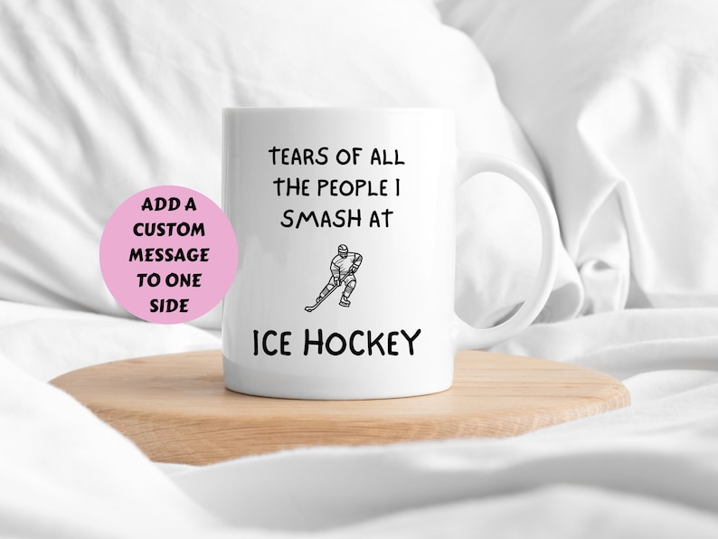 May include: White ceramic mug with black text that reads "Tears of all the people I smash at Ice Hockey". A black and white illustration of a hockey player is shown on the mug.