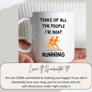 K&ouml;nnte beinhalten: Wei&szlig;e Keramik-Tasse mit dem Text "TEARS OF ALL THE PEOPLE I'VE BEAT RUNNING" in Schwarz. Die Tasse zeigt eine orangefarbene Grafik von zwei L&auml;ufern. Die Tasse wird von einer Person gehalten.
