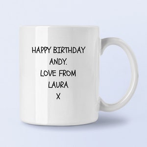 Op de afbeelding: Witte keramische mok met zwarte tekst die "Happy Birthday Andy. Love from Laura X" zegt.