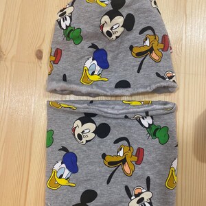 Può includere: Set di cappello e scaldacollo grigio con un motivo ripetitivo di Topolino, Paperino, Pippo e Pluto.