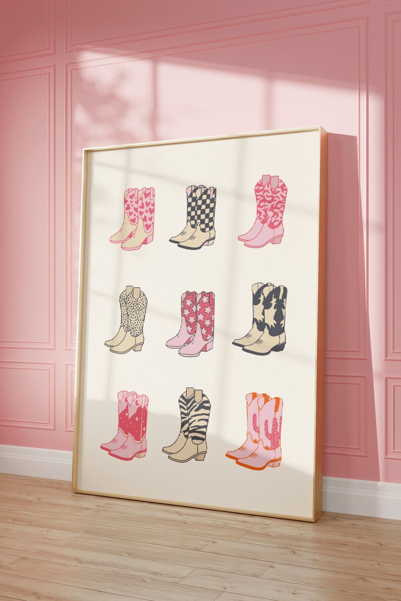 May include: A framed print featuring nine pairs of cowboy boots with different patterns, including hearts, stars, checkered, animal print, and cactus designs. The boots are all pink and white with black accents.