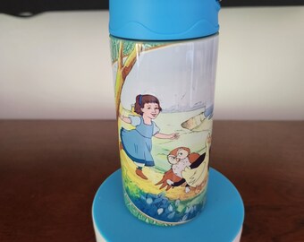 May include: A blue and yellow water bottle with a rotating base. The bottle features a colorful illustration of a girl and two owls. The base has buttons labeled "CW/UP/CCW" and "DC-5V".