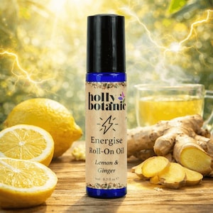 Op de afbeelding: Een roll-on flesje Holly Botanic Energise Oil met een zwarte dop en blauwe basis. Het etiket leest "Lemon & Ginger" en "9ml 0.3 fl oz e". De afbeelding bevat citroenen, gember en een glas thee.