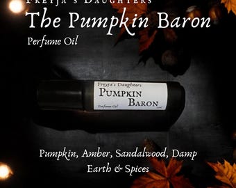 Può includere: Un flacone di olio profumato con tappo nero ed etichetta bianca con la scritta "The Pumpkin Baron" di Freyja's Daughters. L'etichetta elenca anche le note olfattive: Zucca, Ambra, Sandalo, Terra Umida e Spezie.