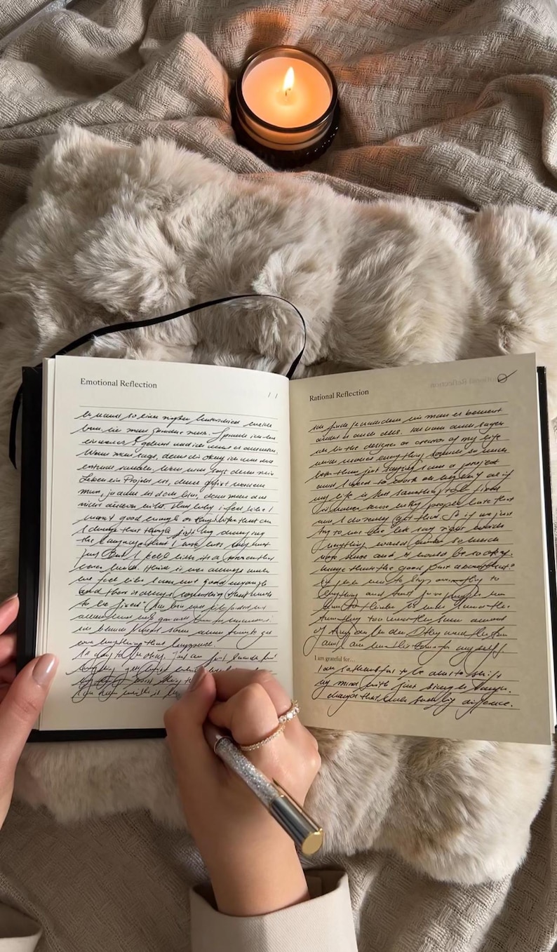 Puede incluir: Diario abierto con cubierta negra y p&aacute;ginas rayadas. Las p&aacute;ginas est&aacute;n llenas de texto escrito a mano con tinta negra. El diario est&aacute; abierto en dos p&aacute;ginas, una titulada "Reflexi&oacute;n emocional" y la otra titulada "Reflexi&oacute;n racional".