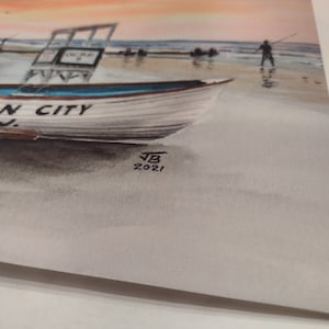 May include: A watercolor painting of a boat on a beach with the words "Ocean City N.J." on the side. The painting is signed "JB 2021" in the bottom right corner.
