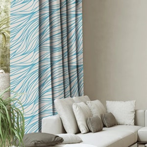 Könnte beinhalten: Weiße Vorhänge mit einem blauen abstrakten Wellenlinienmuster. Die Vorhänge hängen in einem Wohnzimmer mit einem weißen Sofa und Kissen.