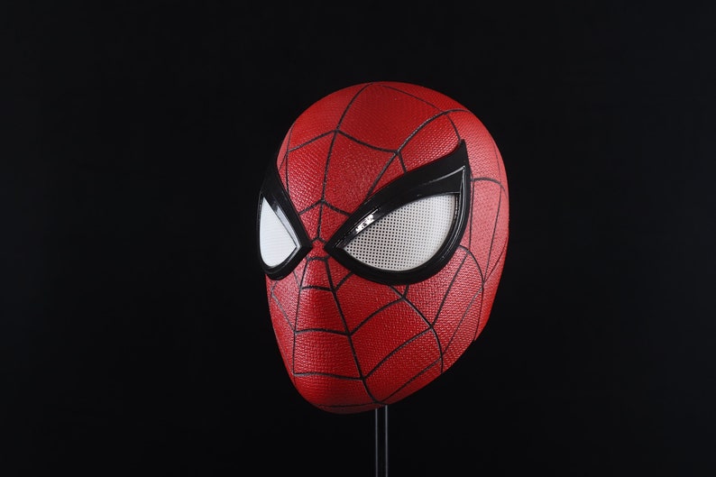 Puede incluir: Una m&aacute;scara de Spider-Man roja y negra con una cubierta de ojo de malla blanca.