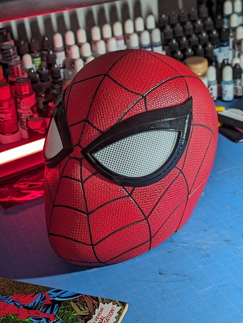 Puede incluir: Una m&aacute;scara de Spider-Man roja y negra con una pieza de ojo de malla blanca. La m&aacute;scara tiene una superficie texturizada y est&aacute; hecha de un material duradero.
